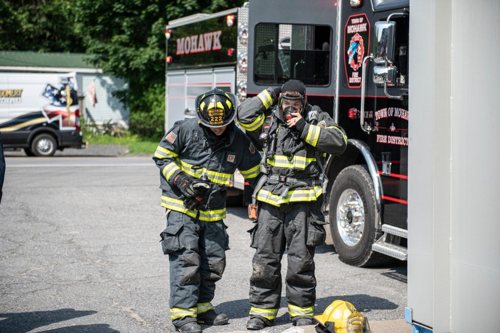 A firemen standing next to a truck.